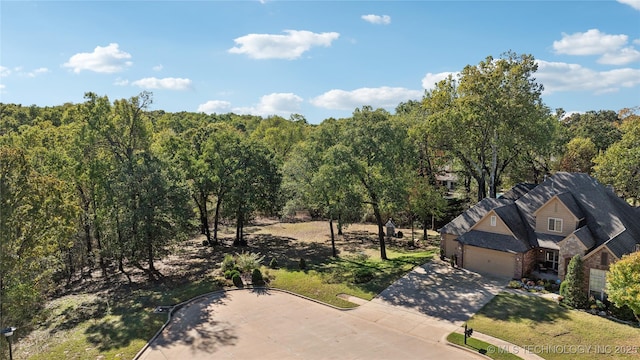 bird's eye view with a wooded view