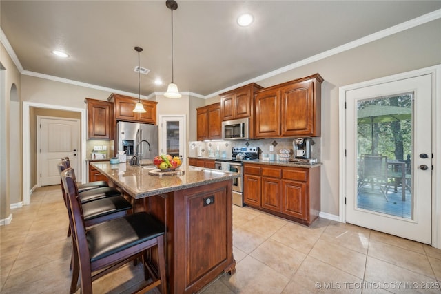 kitchen with stone counters, ornamental molding, appliances with stainless steel finishes, a kitchen bar, and tasteful backsplash