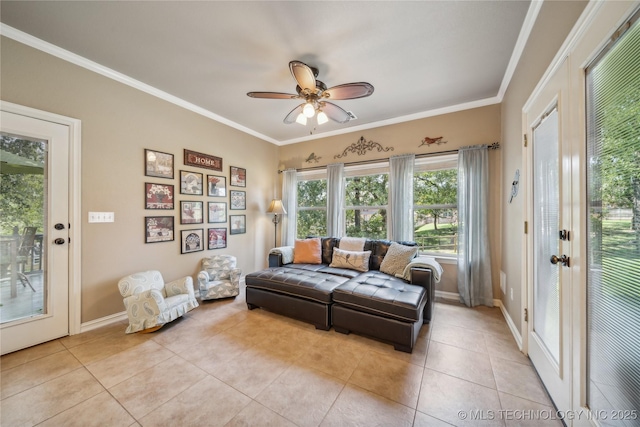 living area with light tile patterned floors, baseboards, a ceiling fan, and crown molding