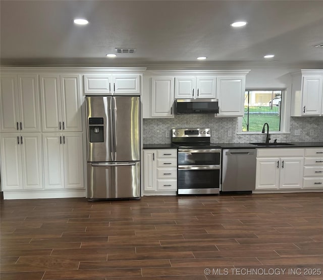 kitchen featuring visible vents, a sink, appliances with stainless steel finishes, white cabinetry, and dark countertops