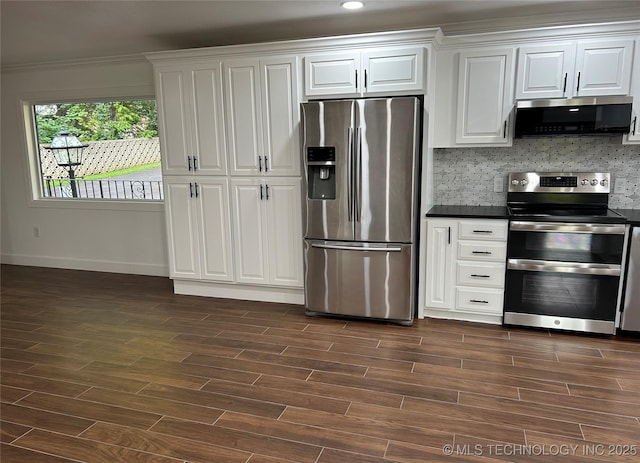 kitchen featuring wood tiled floor, white cabinets, dark countertops, and stainless steel appliances