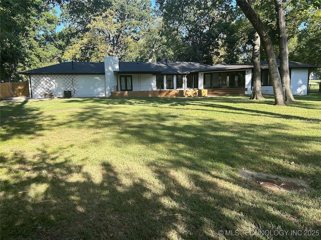 exterior space with a chimney and a front yard