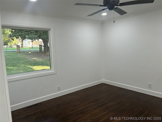 spare room with a healthy amount of sunlight, dark wood-type flooring, and ornamental molding