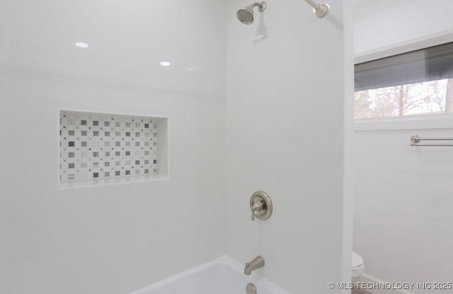 bathroom featuring toilet and shower / bathtub combination