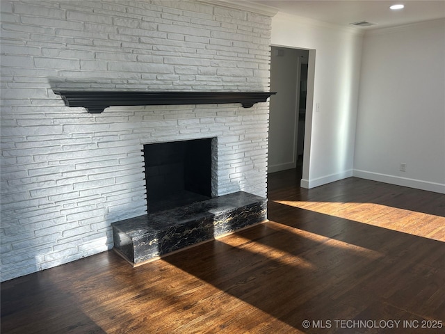 unfurnished living room featuring a stone fireplace, crown molding, wood finished floors, and baseboards