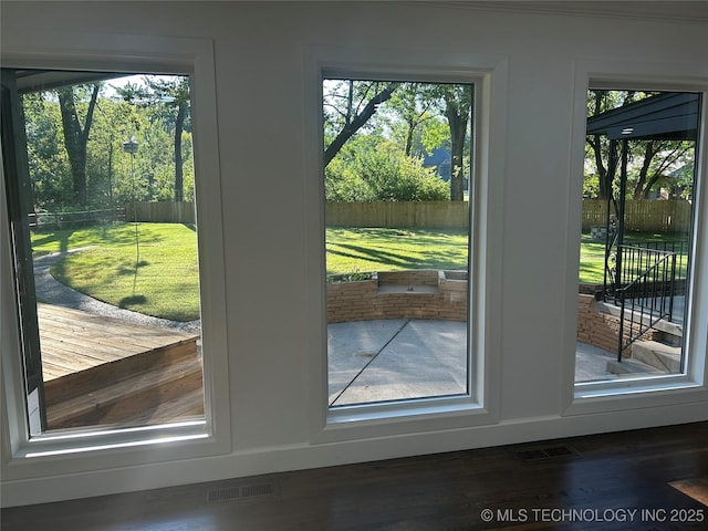 doorway to outside featuring visible vents, a healthy amount of sunlight, and wood finished floors