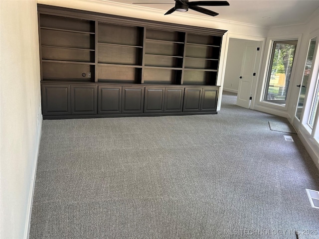 interior space featuring carpet flooring, ceiling fan, crown molding, and visible vents