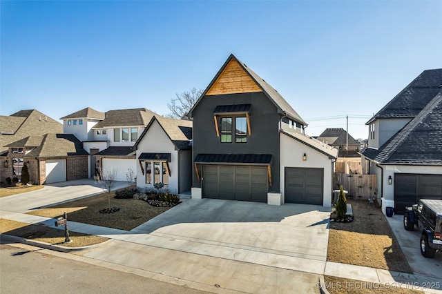 view of front of property with concrete driveway, an attached garage, fence, and stucco siding