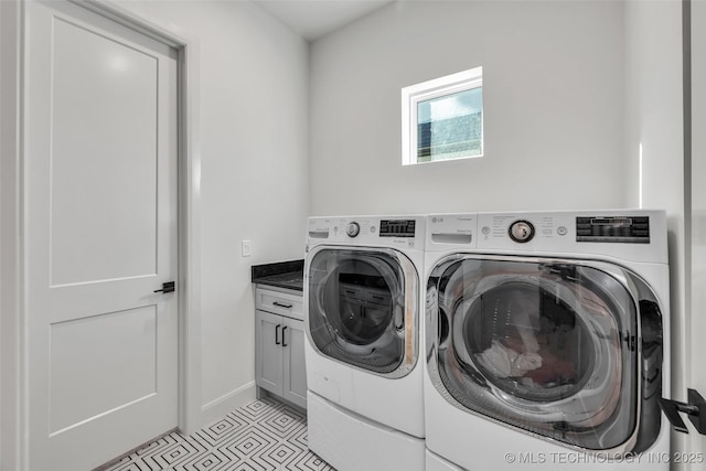 clothes washing area featuring light tile patterned flooring, cabinet space, and independent washer and dryer