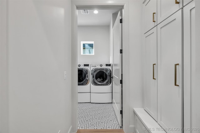 washroom featuring washer and dryer, laundry area, and visible vents