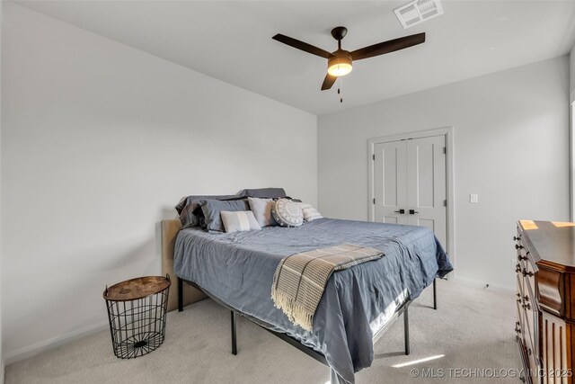 bedroom featuring a ceiling fan, light colored carpet, visible vents, and baseboards