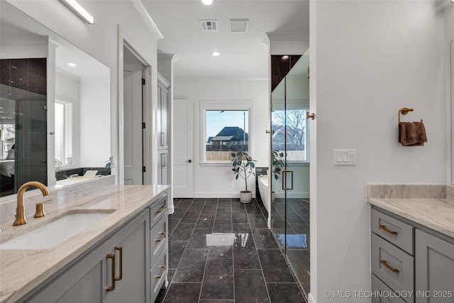 bathroom with visible vents, a stall shower, baseboards, a soaking tub, and vanity