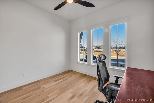 office area with a ceiling fan, light wood-style floors, and baseboards