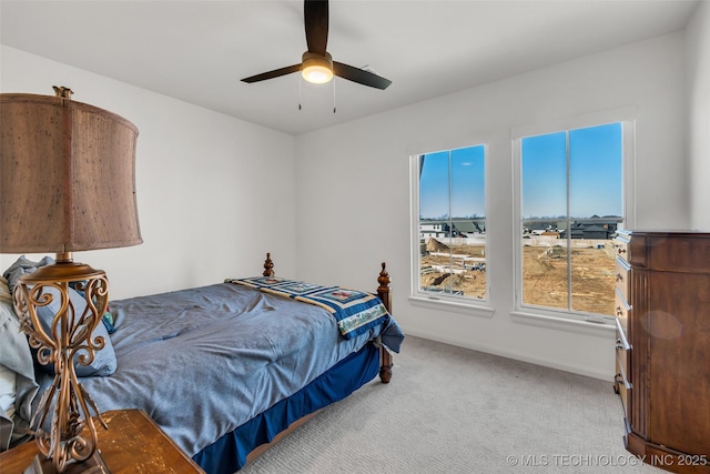 carpeted bedroom featuring baseboards and ceiling fan