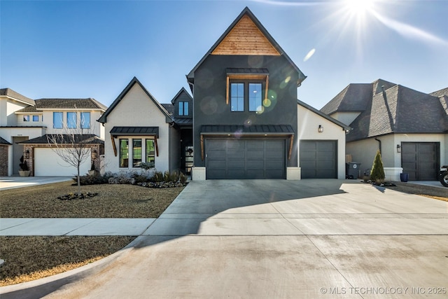 view of front of property with metal roof, a garage, driveway, and a standing seam roof