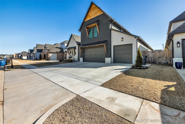 view of front of home featuring a garage, a residential view, driveway, and fence