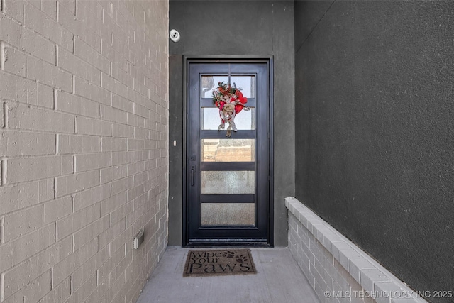 doorway to property featuring stucco siding