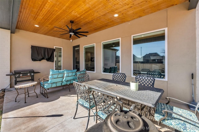 view of patio with area for grilling, outdoor dining area, and a ceiling fan