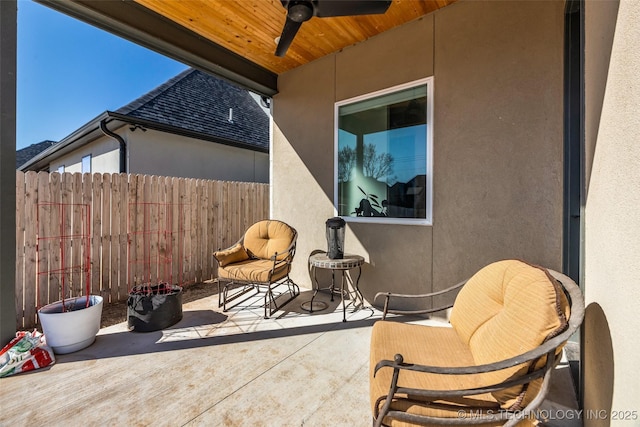 view of patio featuring a ceiling fan and fence