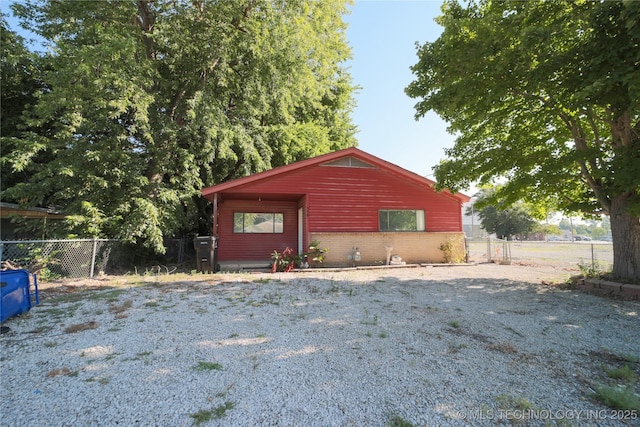 view of side of property featuring fence and brick siding