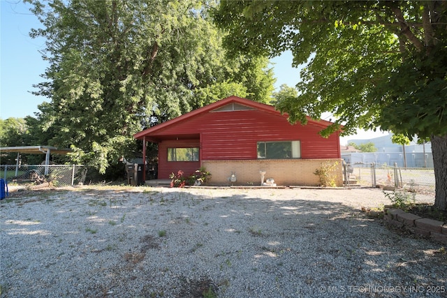 view of front facade featuring a gate, fence, and brick siding