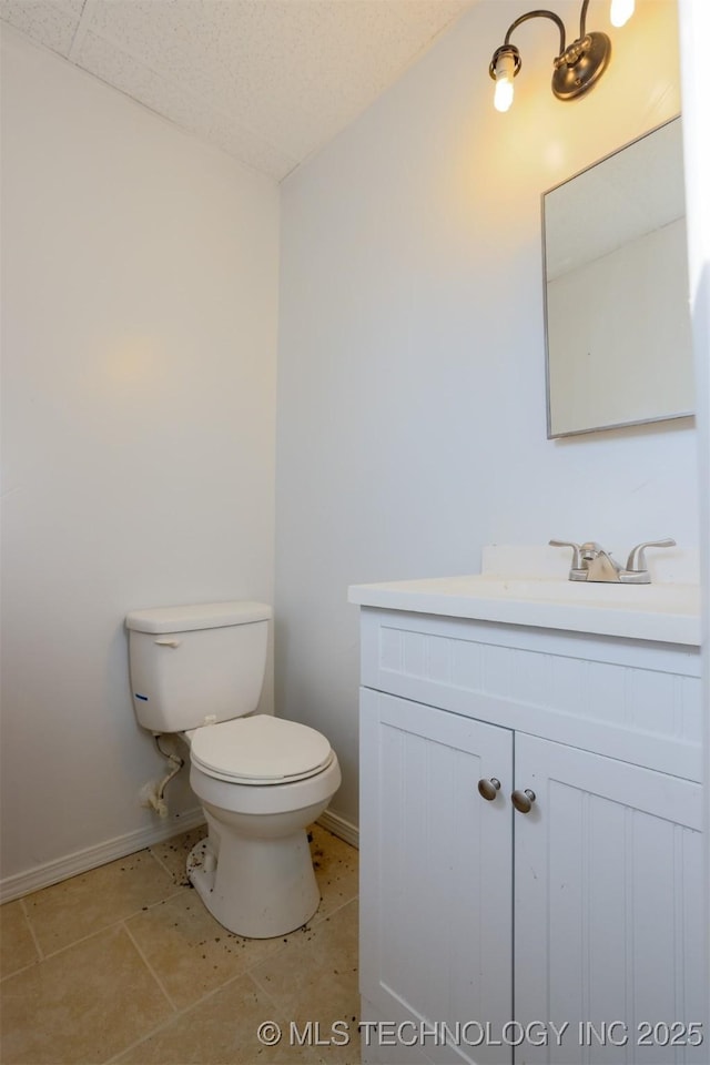 bathroom with vanity, toilet, and baseboards