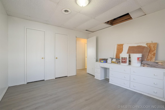 bedroom featuring light wood-type flooring and a paneled ceiling