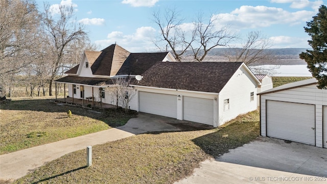 view of front of home featuring a porch, a shingled roof, and a garage