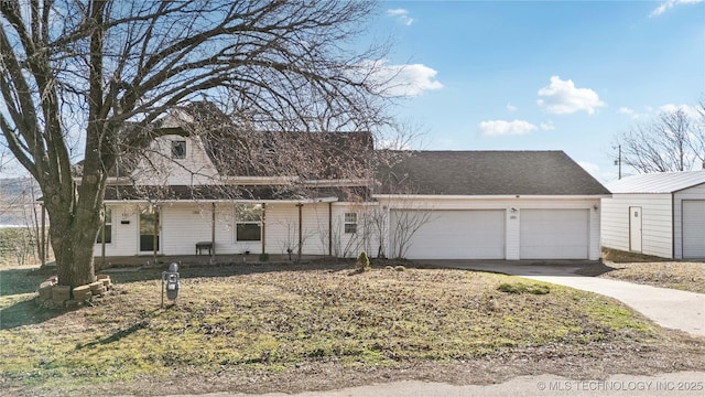 view of front of home featuring a garage, concrete driveway, and a shingled roof