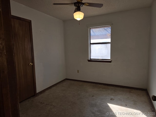 unfurnished bedroom with a textured ceiling, concrete floors, and baseboards