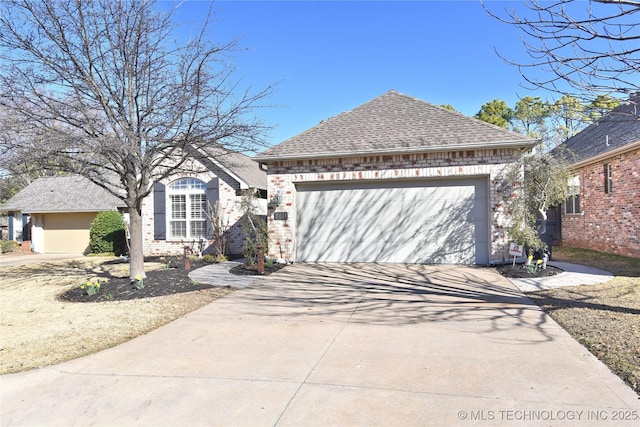 view of front of house featuring concrete driveway, an attached garage, brick siding, and roof with shingles