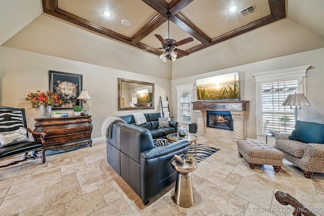 living room featuring visible vents, coffered ceiling, ceiling fan, a tile fireplace, and stone tile flooring