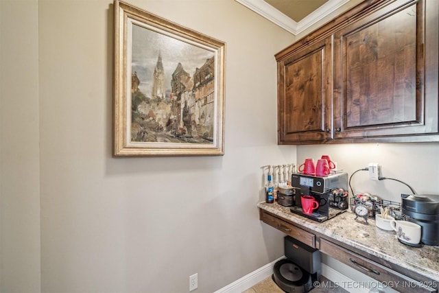 interior space with light stone counters, built in study area, baseboards, and ornamental molding