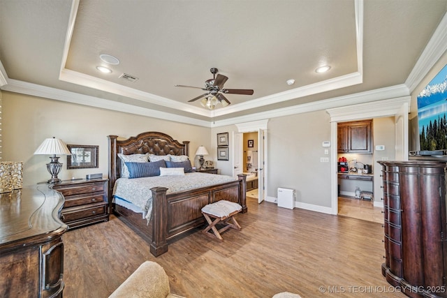 bedroom featuring a tray ceiling and wood finished floors