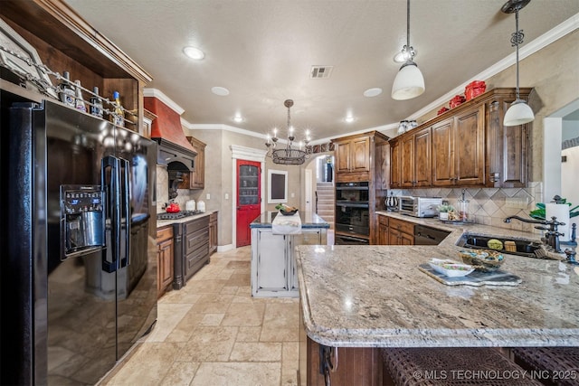 kitchen featuring premium range hood, ornamental molding, stone tile flooring, black appliances, and a sink