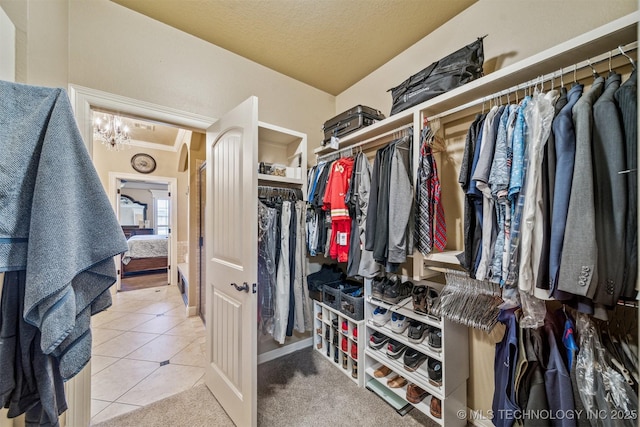 walk in closet featuring an inviting chandelier and tile patterned floors