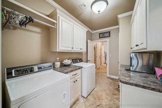 washroom with baseboards, visible vents, cabinet space, crown molding, and washer and clothes dryer