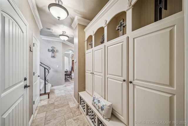7161 Hackberry Rdg, Owasso, OK 74055 - mudroom featuring crown molding, stone tile floors, arched walkways, and baseboards