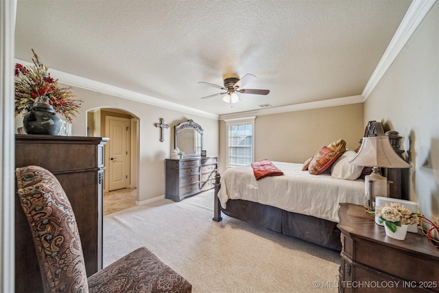 bedroom with ornamental molding, light carpet, arched walkways, a textured ceiling, and a ceiling fan