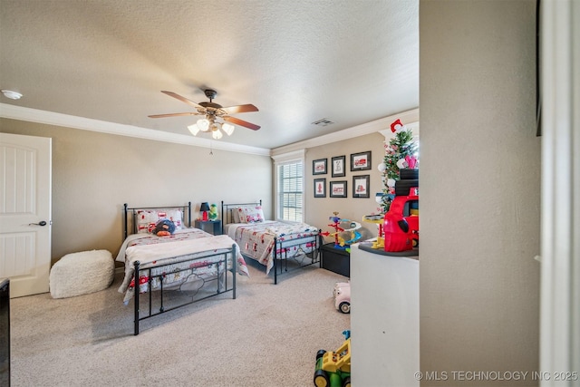 carpeted bedroom featuring visible vents, a textured ceiling, ornamental molding, and a ceiling fan