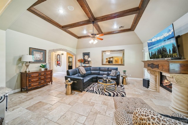 7161 Hackberry Rdg, Owasso, OK 74055 - living area with arched walkways, coffered ceiling, baseboards, a premium fireplace, and stone tile flooring