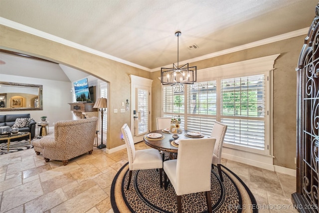 7161 Hackberry Rdg, Owasso, OK 74055 - dining area featuring stone tile floors, a chandelier, baseboards, and crown molding