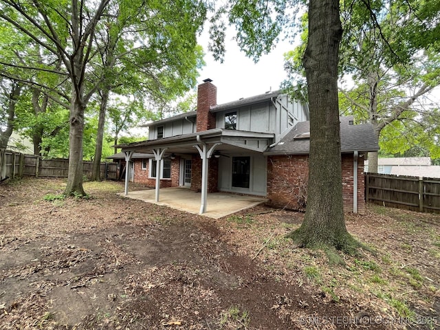 back of house with a patio, brick siding, and a fenced backyard