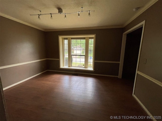 unfurnished room with visible vents, baseboards, ornamental molding, and dark wood-style flooring