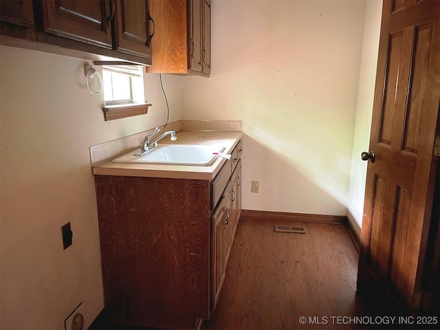 bathroom featuring vanity, visible vents, wood finished floors, and baseboards