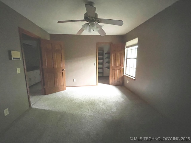 carpeted spare room featuring ceiling fan