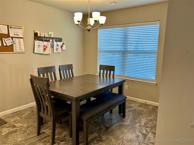 dining area with baseboards and an inviting chandelier