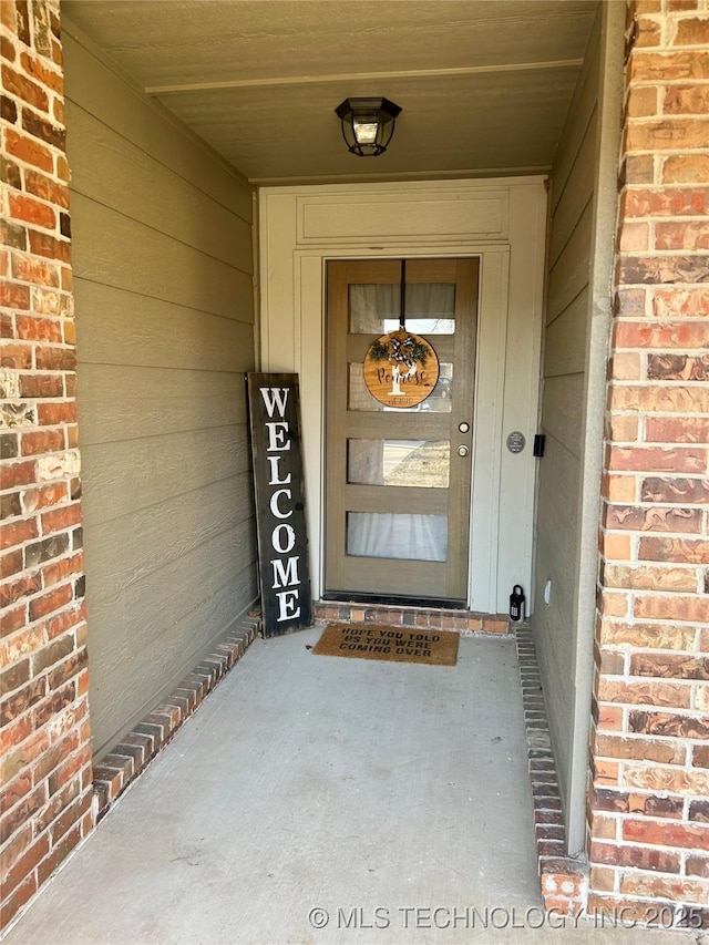 entrance to property featuring brick siding