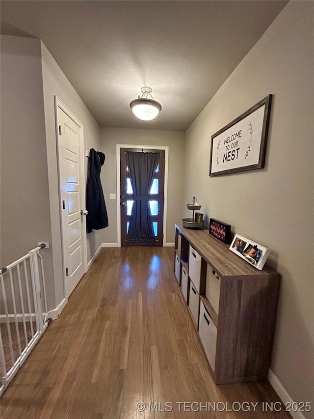 foyer with baseboards and wood finished floors