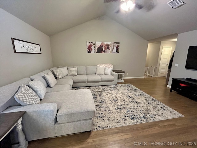 living area featuring visible vents, lofted ceiling, wood finished floors, and a ceiling fan